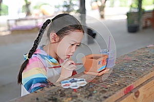 Kid painting, Portrait little child girl intend to paint on earthenware dish