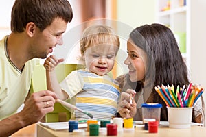 Kid painting together with parents ay home