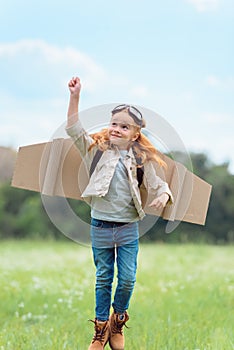 kid in pilot costume with outstretched arm jumping