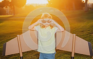 Kid with pilot glasses traveller with backpack wings. Child playing pilot aviator and dreams outdoors in park.