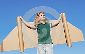 Kid pilot with toy jetpack against sky background. Happy child playing outdoors. Happy childhood. Children imagination