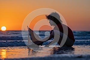 Kid play on the beach on a sunny day. Little sailor play with sailing boat in sea water. Child dreams of travel and