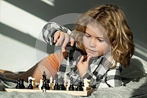 Kid play chess at home. Child thinking near chessboard. Learning and growing children, childgood. Kids early development