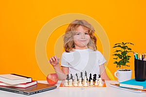 Kid play chess on isolated studio background. Little kid play chess. Thinking child. Chess game for kids. Intelligent