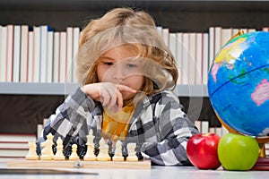 Kid play chess at school. Chess for intelligent kid. Child genius, smart pupil playing logic board game. Clever school