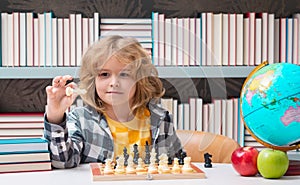 Kid play chess at school. Little kid play chess. Thinking child. Chess game for kids. Intelligent, smart and clever