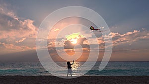 Kid playing on beach on seashore, child flying kite at sunset on ocean, happy little girl on coastline