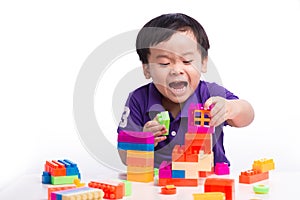 kid playing with block toys, asian small boy playing indoor games, colorful plastic block toys, making toy house, over white