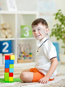 Kid playing with building blocks at home or kindergarten