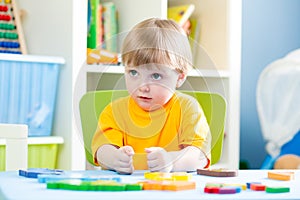 Kid playing with building blocks at home or kindergarten