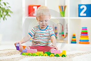 Kid playing with building blocks at kindergarten