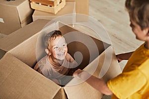 Kid Playing in Cardboard Box
