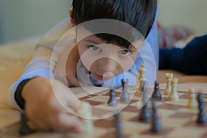 Kid playing chess in his house