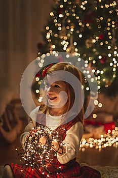Kid playing with Christmas lights