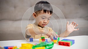 The kid playing with colorful toy blocks. Little boy building the car of block toys. Educational and creative toys and games for