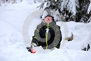 Kid playing in deep snow with red shovel