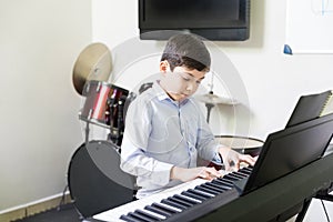 Kid Playing Electric Piano In Music School