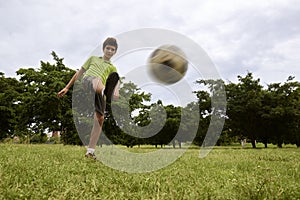 Kid playing football and soccer game in park