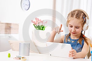 Kid playing games at tablet at home