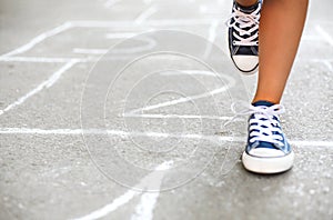 Kid playing hopscotch on playground outdoors