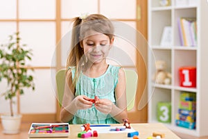 Kid playing modeling plasticine or molding clay