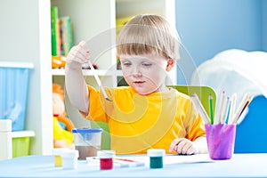 Kid playing and painting at home or kindergarten or playschool