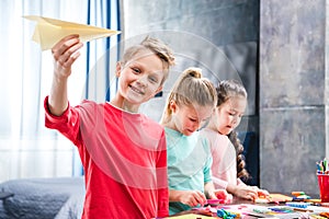 Kid playing with paper plane schoolchildren