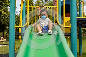 kid playing at the park playground with medical face mask during day time