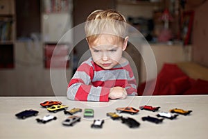 Kid playing with plenty of toy cars