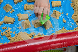 Kid playing sand and plastic mould
