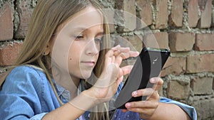 Kid Playing at Smartphone, Young Girl Browsing Internet in Park, Blonde Child Surfing Touchscreen Smart Phone