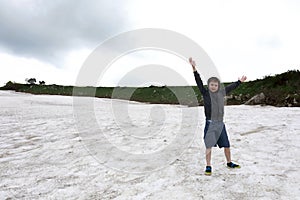 Kid playing on snowfield of Lago-Naki plateau