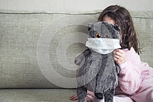 Kid playing with soft toy on couch during COVID-19 coronavirus pandemic, background for text