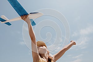 Kid playing with toy airplane. Children dream of travel by plane. Happy child girl has fun in summer vacation by sea and