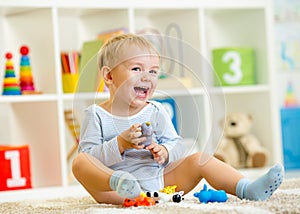 Kid playing with toy animals indoors