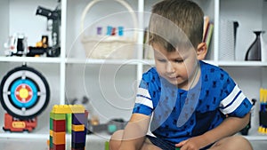 Kid playing toy blocks in white room