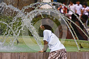 Kid playing with water fountain