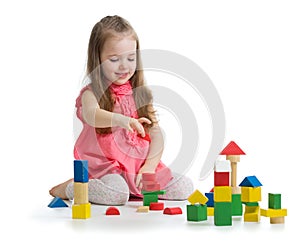 Kid playing with wooden block toys. Baby girl building castle using cubes. Educational toys for preschool and