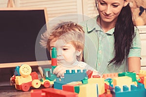 Kid plays with colorful plastic bricks on table.