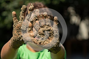 Kid plays outside in the mud