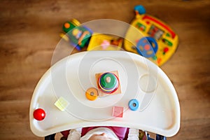 The kid plays the pyramid. child playing with toys view from above