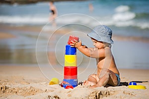 Kid plays with toys at the seashore in summertime