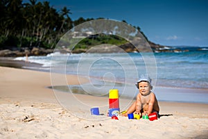 Kid plays with toys at the seashore in summertime