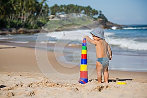 Kid plays with toys at the seashore in summertime