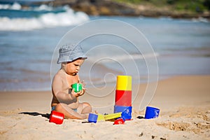 Kid plays with toys at the seashore in summertime