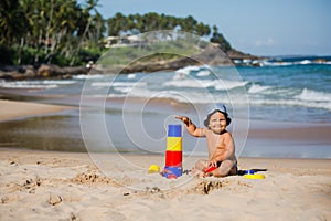 Kid plays with toys at the seashore in summertime