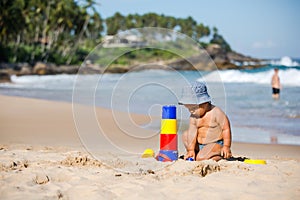 Kid plays with toys at the seashore in summertime