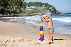 Kid plays with toys at the seashore in summertime