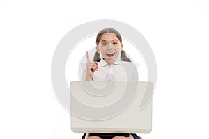 Kid point finger up isolated white. Schoolgirl with laptop pointing upwards. Schoolgirl having idea or recommend check