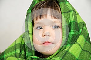 Kid portrait in blanket warming, happy smiling kid face expressing emotion, little girl looking at camera, warm blanke